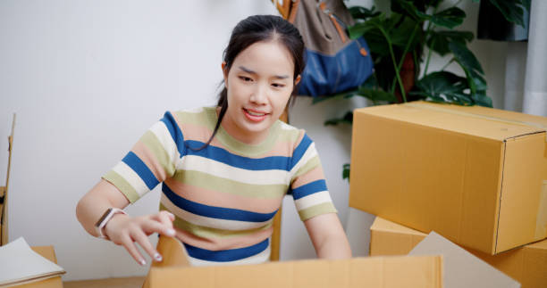 istock Moving out : Young woman opened the box containing the items. 2165317332