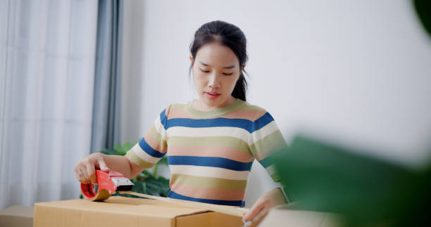 istock Young woman closes a box that has already been packed. 2165317694
