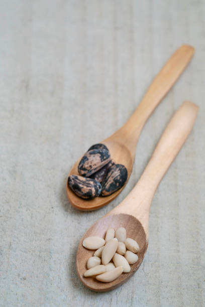 nut, spoons with pine nuts on wooden background or surface with copy space. food ingredients background. dried fruits on table