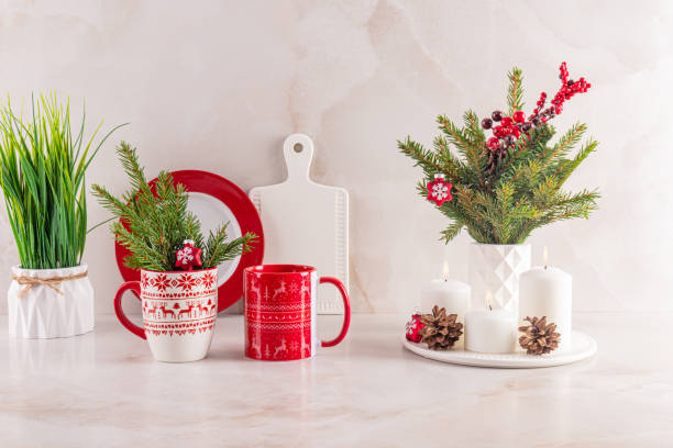 istock Christmas bright mugs with ornaments, spruce branches, cones, decorations on the kitchen marble countertop in a modern kitchen interior. Front view. 2165319518