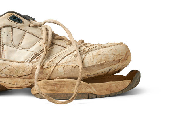 High angle shot wasted running shoe lying on the ground at sunny day