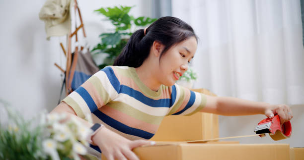 istock Young woman closes a box that has already been packed. 2165321146