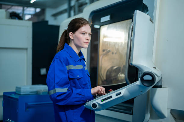 Female Robotics engineers Using Controller to Remotely Operate programming and Manipulating Robot Hand, Industrial Robotics Design, High Tech Facility, Modern Machine Learning. Mass Production Automatics. stock photo