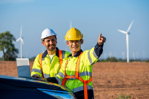 istock Diverse ethnicity male technicians working in the wind turbines field. Innovation engineer men use laptop computer work to develop environmental renewable clean energy outdoors at windmill power farm. 2165324964