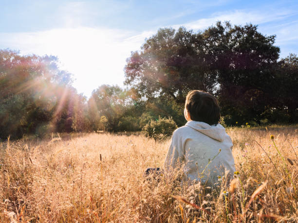 istock A boy enjoying at the sunset in a tranquil field. 2165326771