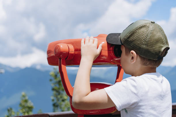 istock boy observing mountains panorama through stationary binoculars 2165327369