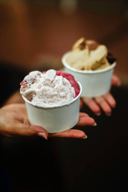 istock Hand holding two cups of ice cream 2165337589