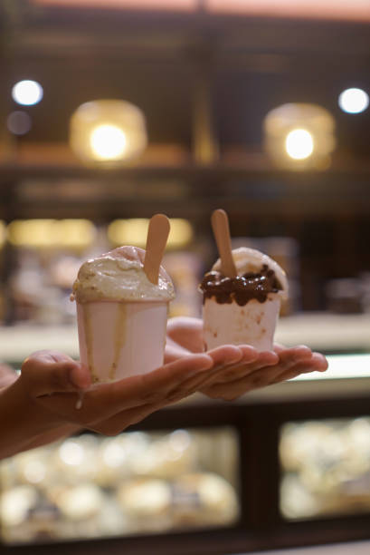 istock Hand holding two cups of ice cream 2165337598