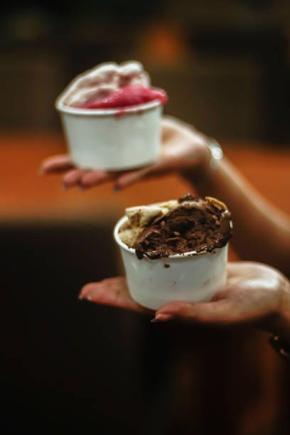 istock Hand holding two cups of ice cream 2165337678
