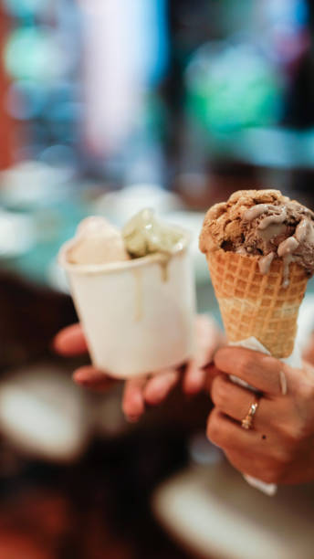 istock Hand holding a cup and a cone of ice cream 2165338050