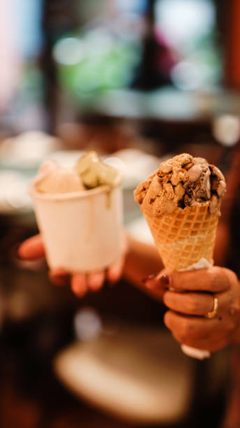 istock Hand holding a cup and a cone of ice cream 2165338104
