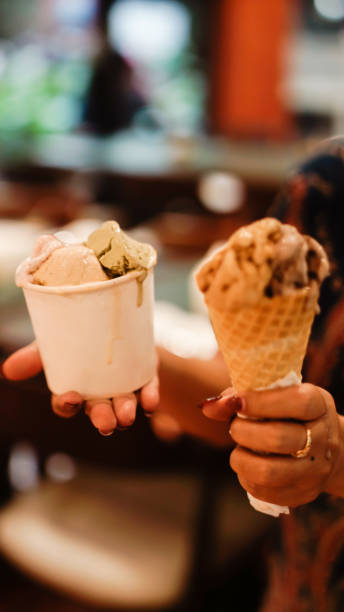 istock Hand holding a cup and a cone of ice cream 2165338119