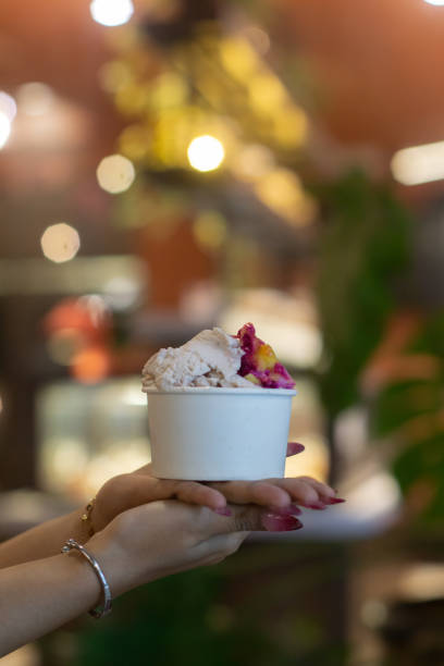 istock Hand holding a cup of ice cream 2165338409
