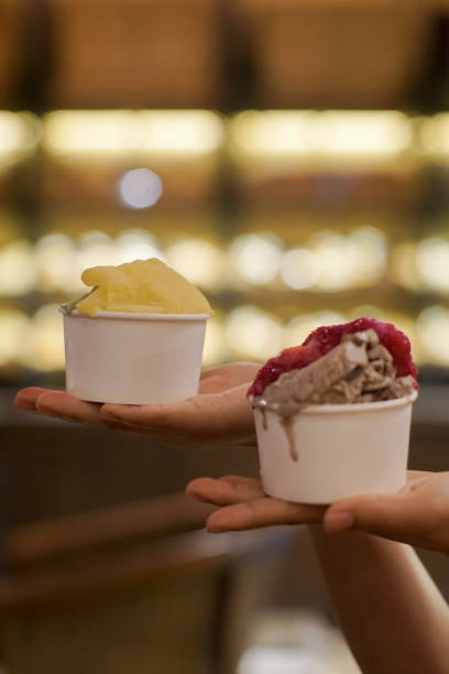 istock Hand holding two cups of ice cream 2165338482