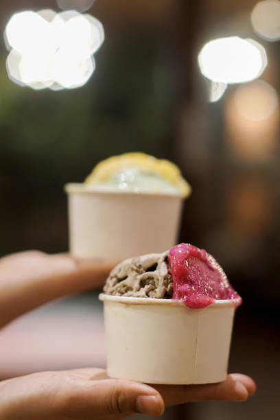 istock Hand holding two cups of ice cream 2165338545
