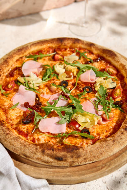 istock Summery Mortadella and Artichoke Pizza with Arugula in Sunlit and Shadowed Setting 2165338919