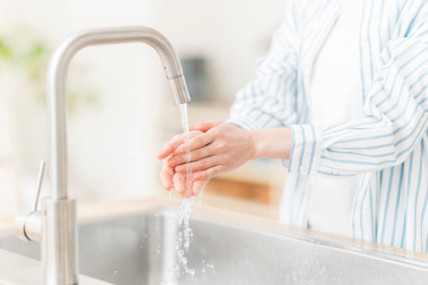 istock Woman washing her hands in the kitchen 2165342687