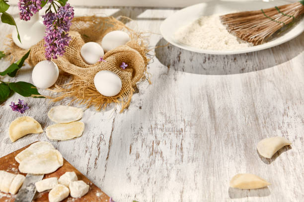 Rustic Baking Setup with Eggs, Dough, and Flour on a Wooden Board in Sunlight.