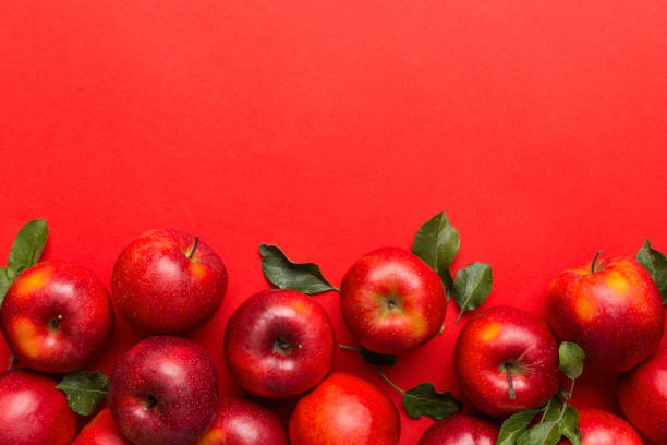 istock Many red apples on colored background, top view. Autumn pattern with fresh apple above view with copy space for design or text 2165347023