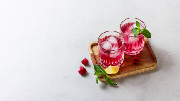istock Raspberry cocktail with ice in a glass on a light background 2165348039