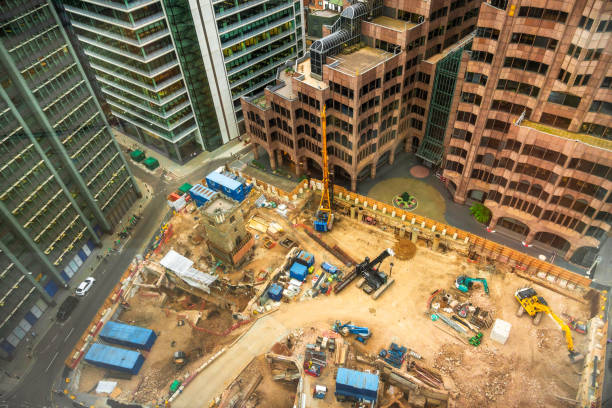 Aerial view looking down on a construction site in the heart of the city of London, UK. The construction site is full of machinery and equipment ready to start the construction of a new office building in the city.