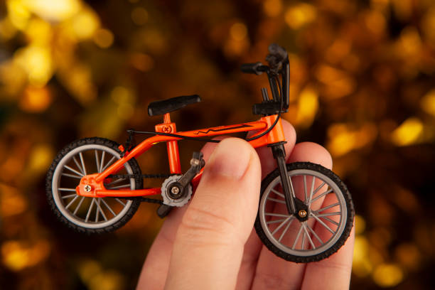istock image of miniature bicycle hand dark background 2165351811