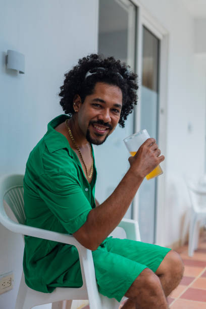 istock Man looks at the camera in a portrait while enjoying a cold beer while on vacation in the beautiful city of Cartagena 2165354781