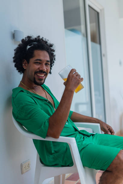 istock Man looks at the camera in a portrait while enjoying a cold beer while on vacation in the beautiful city of Cartagena 2165354803