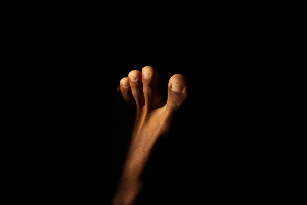 Man's feet with sunlight entering a dark room