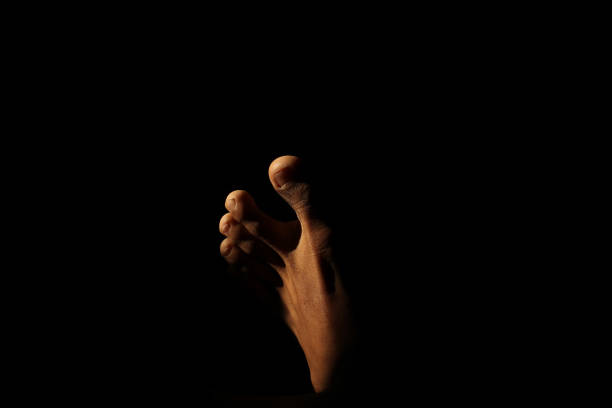 istock Man's feet with sunlight entering a dark room 2165357962