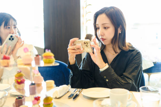istock Young women enjoying afternoon tea at cafe 2165358179