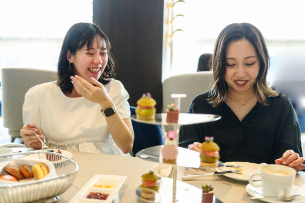 istock Young women enjoying afternoon tea at cafe 2165358383