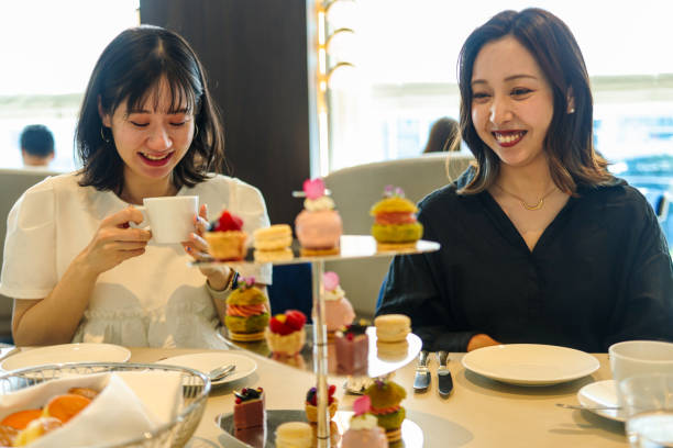 istock Young women enjoying afternoon tea at cafe 2165358914