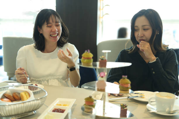 istock Young women enjoying afternoon tea at cafe 2165358955