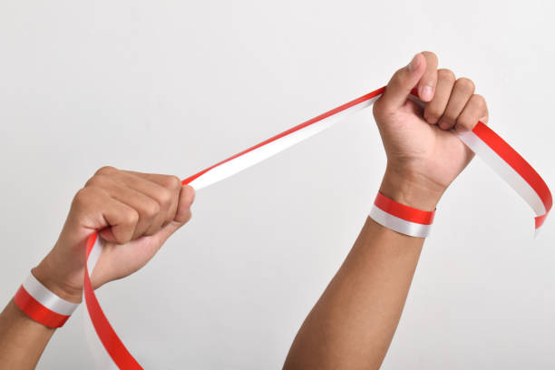 istock Both clenched hands holding red and white ribbon. Indonesian Independence Day concept 2165358982