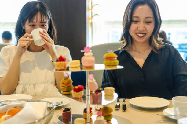 istock Young women enjoying afternoon tea at cafe 2165359225