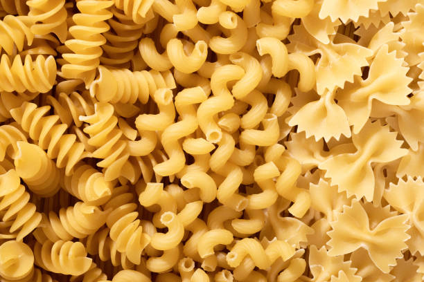 istock Pasta raw closeup background. Textured variety shapes. Top view 2165359391