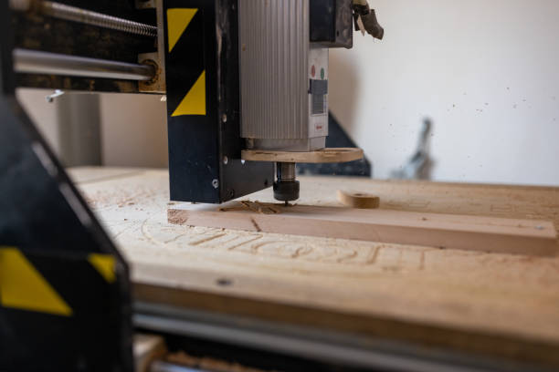 Computer control machine for wood engraving shape on wooden plank.