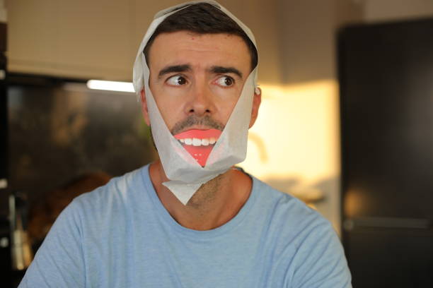 A very sad looing Caucasian man in his early forties is pretending to be happy. He uses a fake smile to cover his problems.