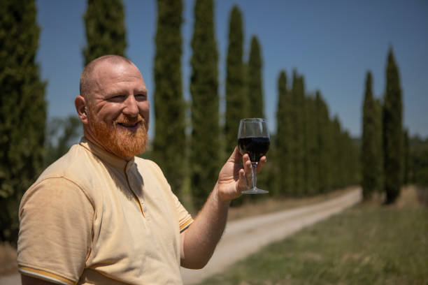 A handsome redhead farmer owner of an ecological small business vineyard in the Italian countryside on a sunny day