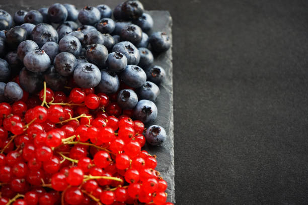 Bunch of mixed berries in harvest pile on white background. Colorful composition with fresh organic strawberry, blueberry, blackberry & redcurrant. Clean eating concept. Close up, copy space, top view