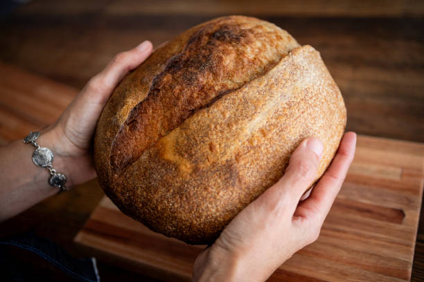 istock Close-up of woman's hands with sourdough fresh bread 2165372469