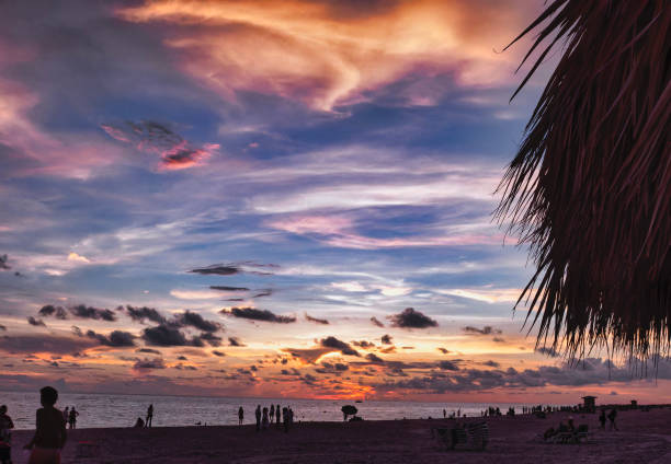 Young people at sunset on the beach at Rum Point, an enchanting place in Grand Cayman characterised by white sand and shallow clear waters