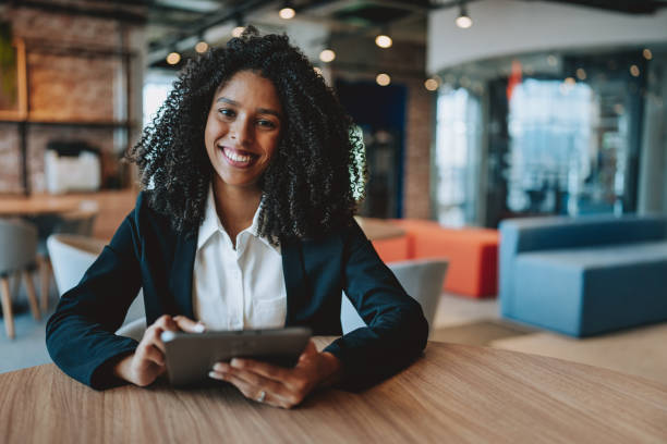istock Young businesswoman using digital tablet looking at camera 2165381041