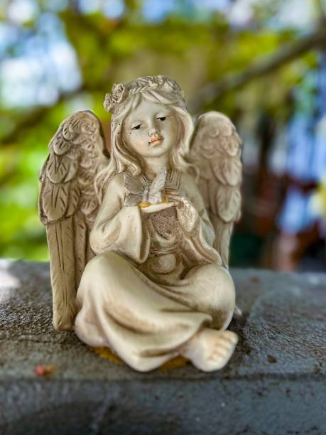 istock Charming Angel Statues in Serene Garden Setting 2165381800