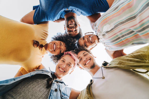 istock Group of happy friends hugging each other looking at camera 2165382877