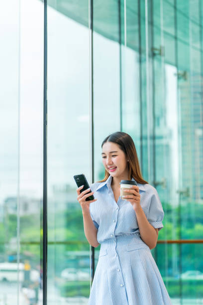 istock Young Woman Using Phone While Having A Cup of Coffee 2165387626