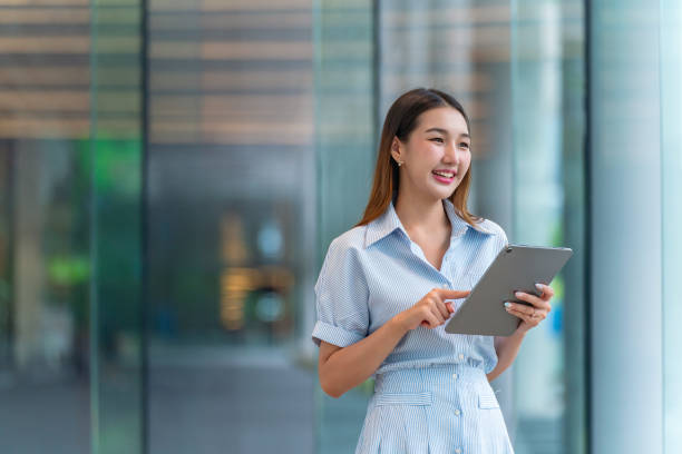 istock Young Asian Woman Using A Tablet, Looking Away Contented 2165387807