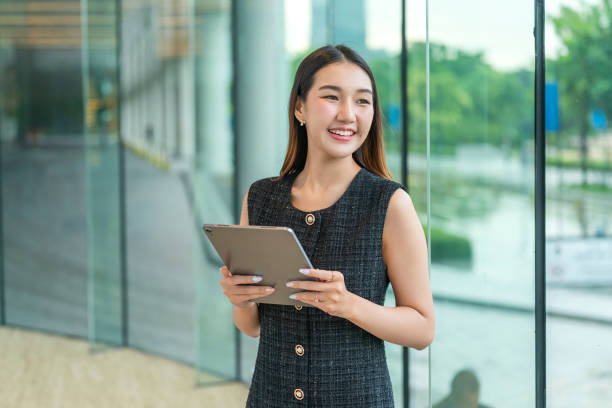 Young Woman Holding A Tablet, Looking Away Smiling