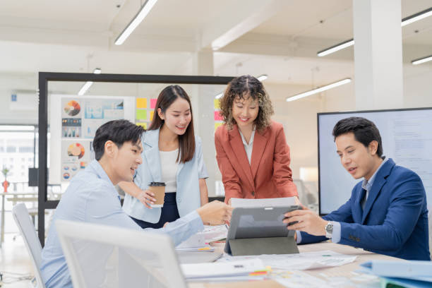istock Creative Asian professionals brainstorming in a modern office. Business team collaborating on innovative ideas and strategies in a contemporary workspace, emphasizing teamwork and dynamic thinking 2165389725